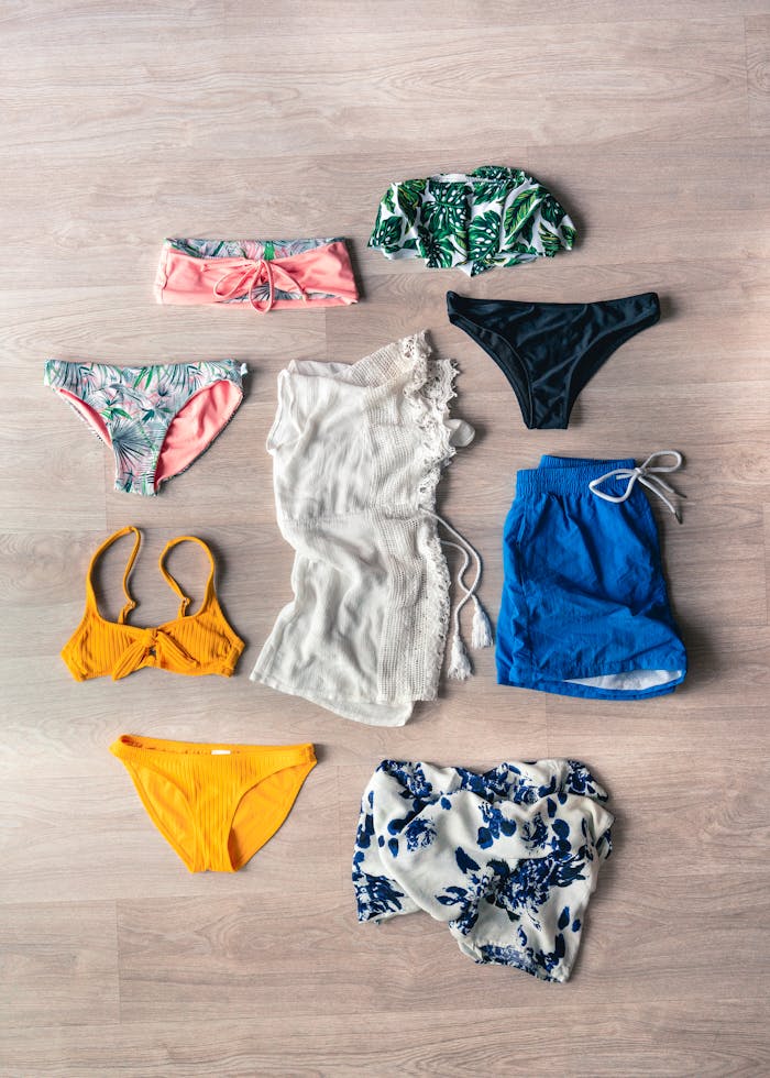 best-selling product-01 Colorful swimwear arranged in a flat lay on a wooden floor, showcasing summer fashion.