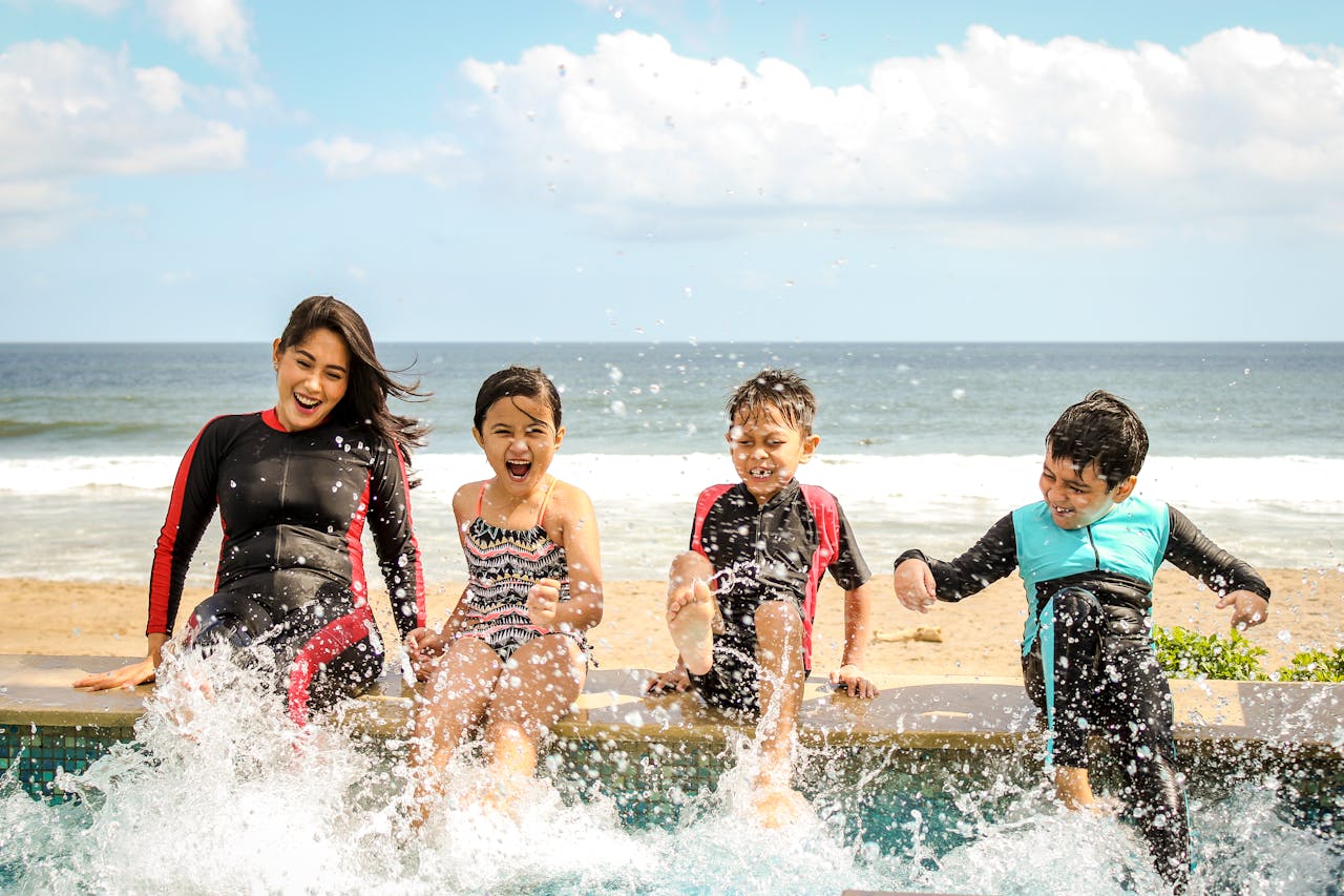 social-feed-img-05 A family having fun splashing water near the seashore on a sunny day in Bali, Indonesia.